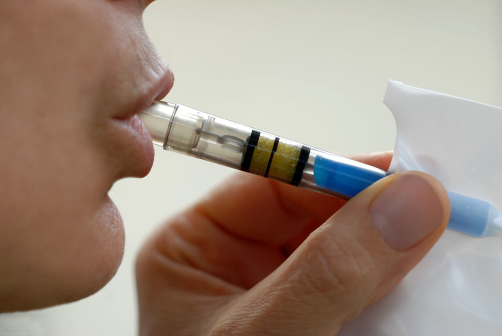 Person breathing into breathalyzer-type device