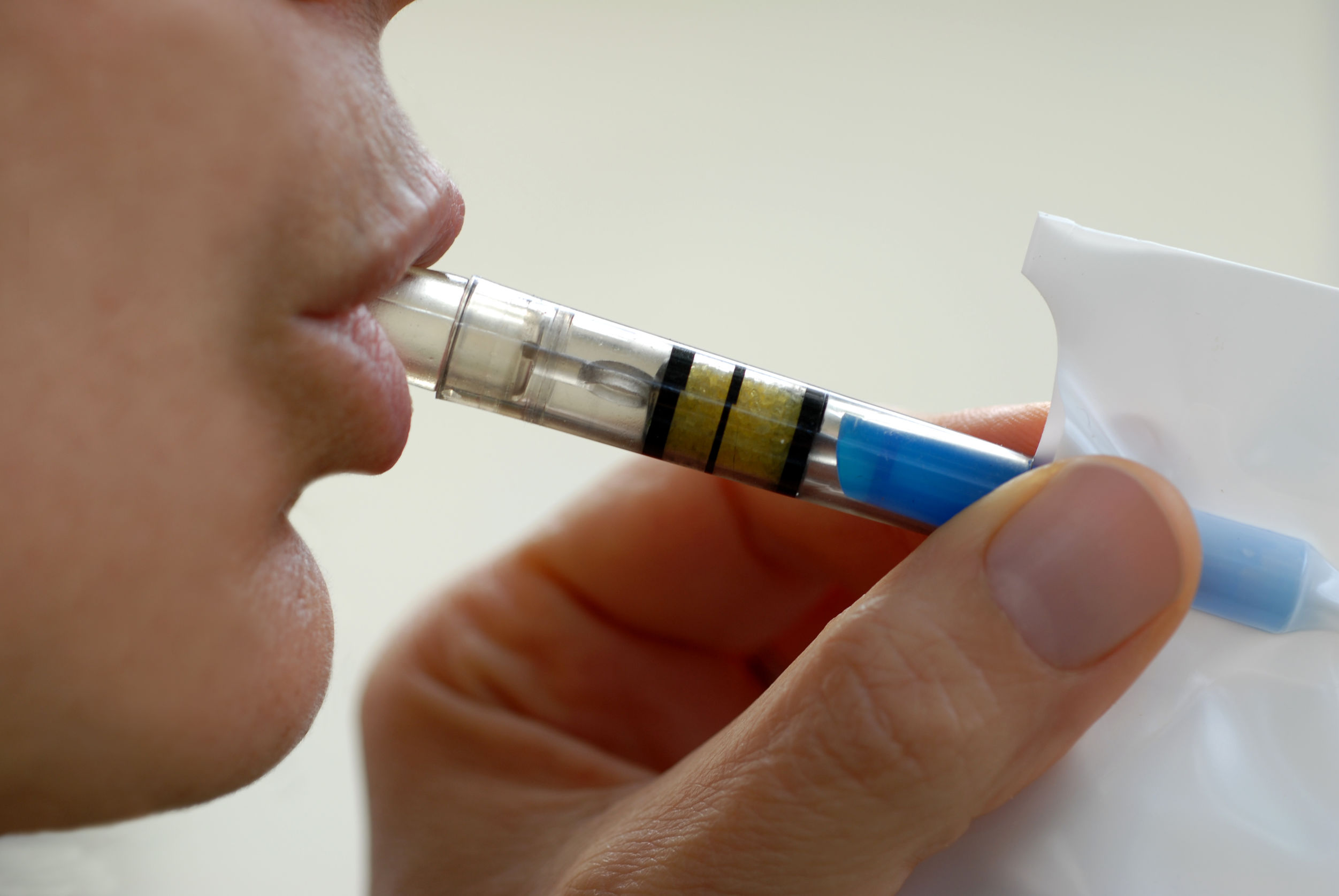 Person breathing into breathalyzer-type device