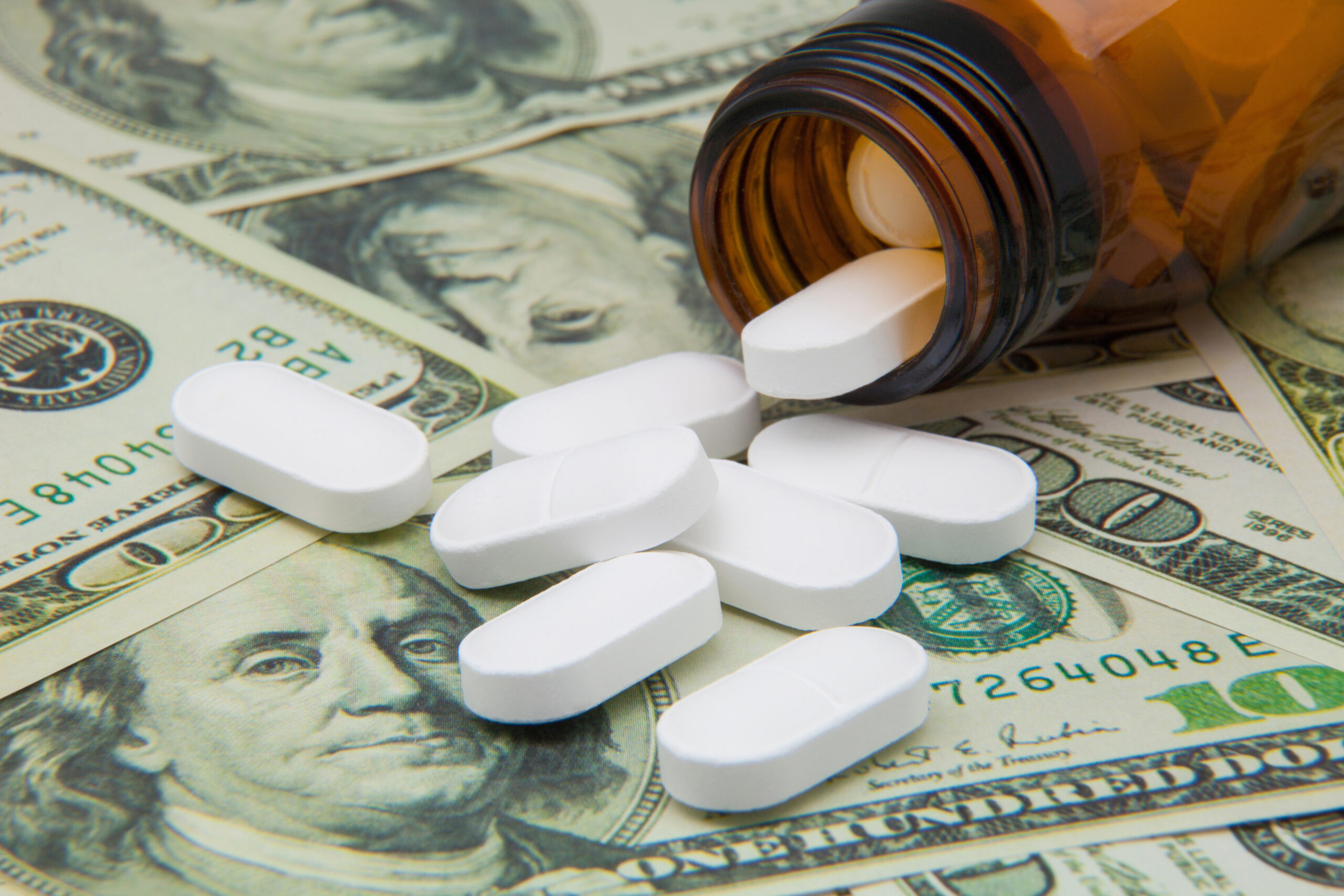 White pills spilling over money
