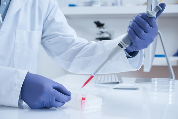 Scientist pipetting liquid into tube