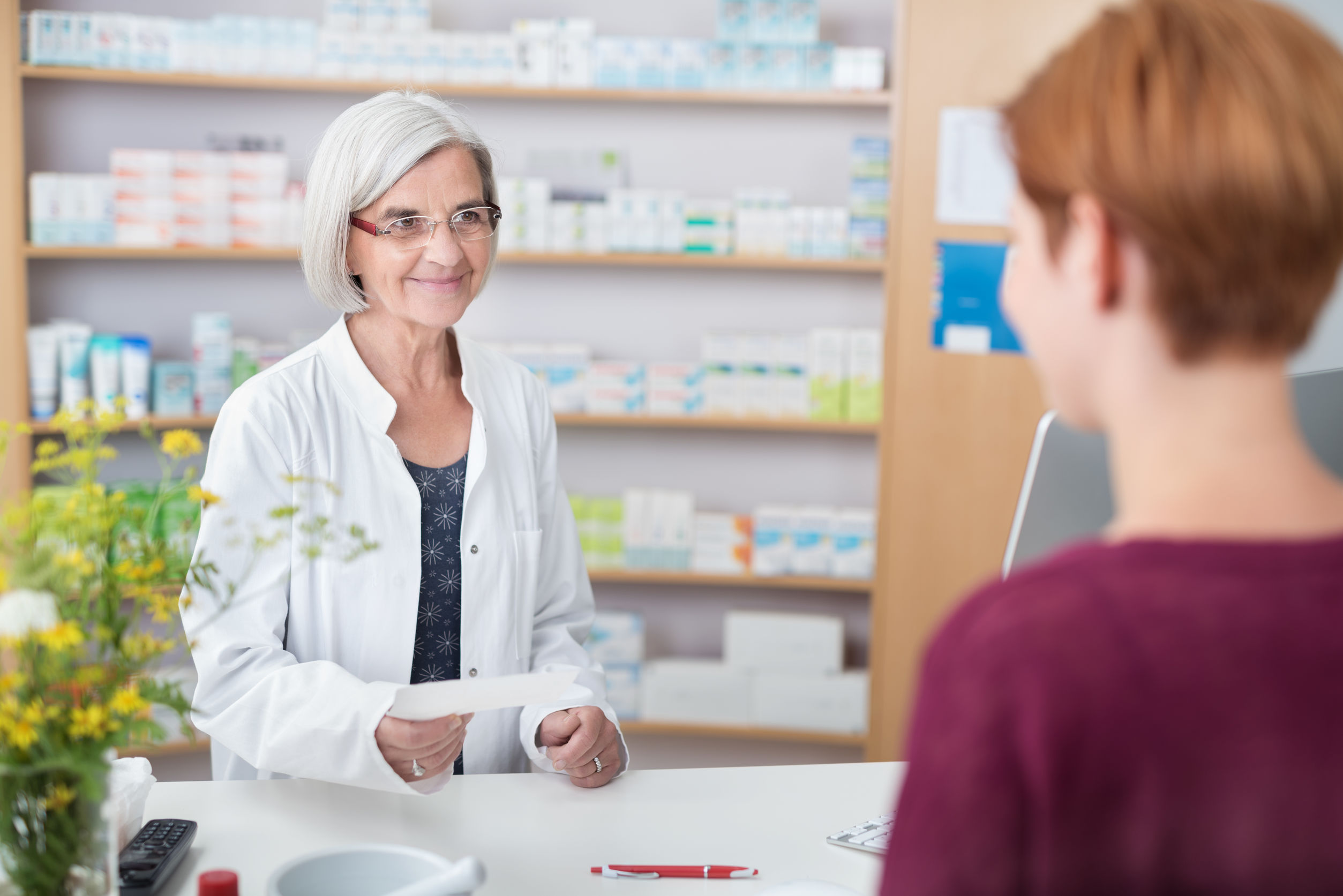 Friendly female pharmacist helping a client